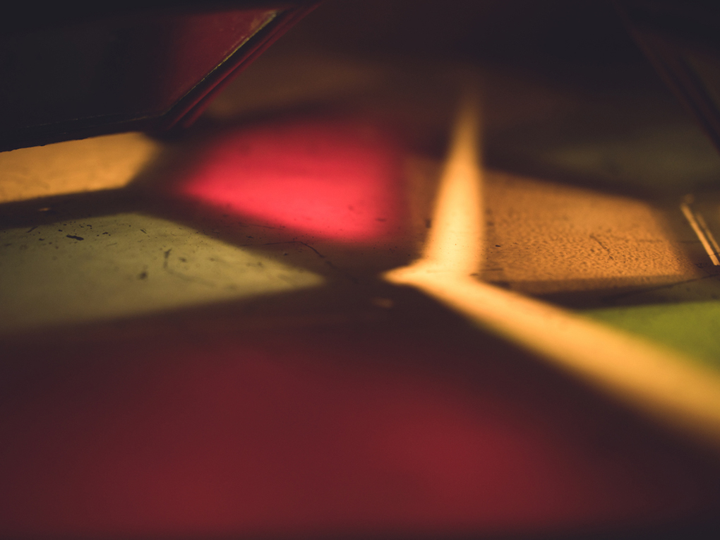 Shards of light in various colours resting on the ground outside a lantern stall at the Bath Christmas Market.