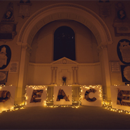 Art installation of golden feathers spelling out the word 'Peace' in St Swithin's Church in Bath.