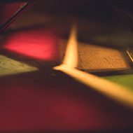 Shards of light in various colours resting on the ground outside a lantern stall at the Bath Christmas Market.