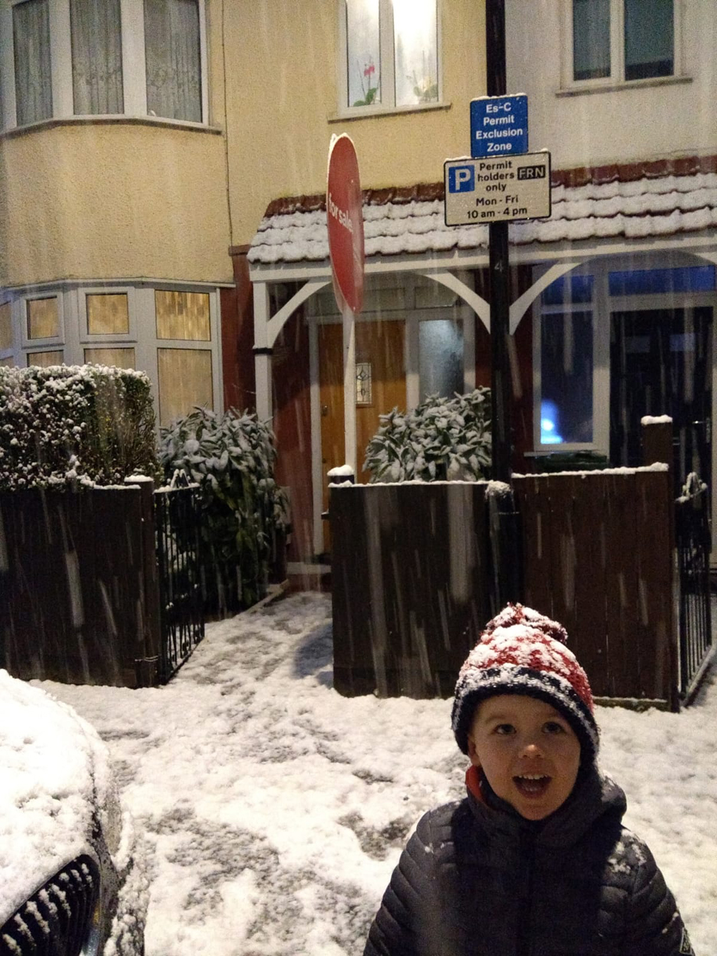 child outside a house in a snowy London street