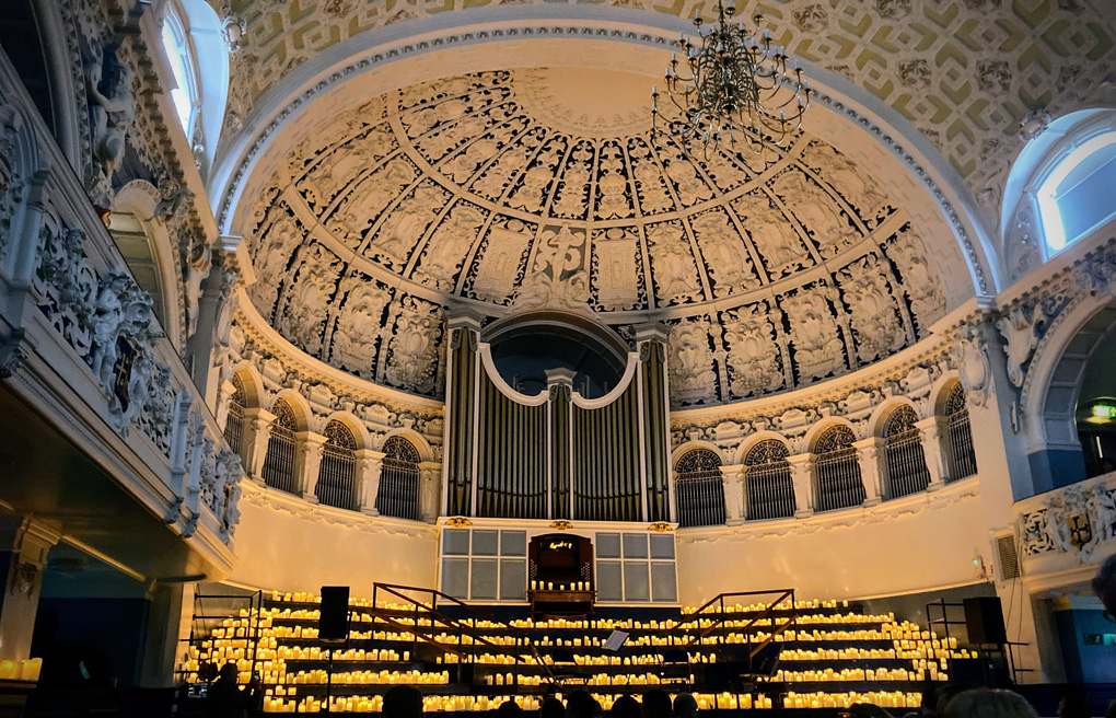 Image of the stage in the Oxford Town Hall covered by very convincing electric candles and the wonderful domed ceiling and huge pipe organ.