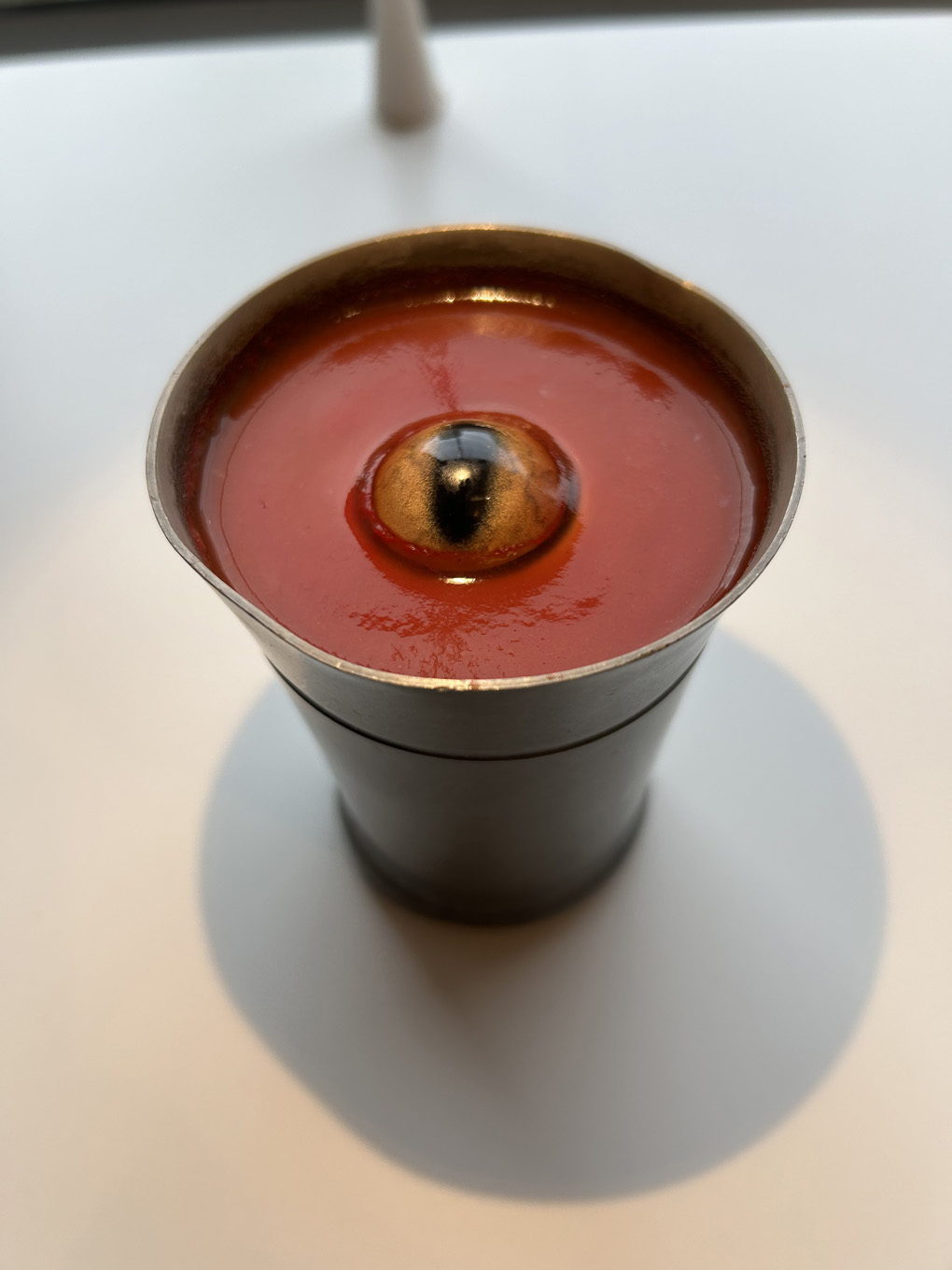 An eye floating in red tomato juice
