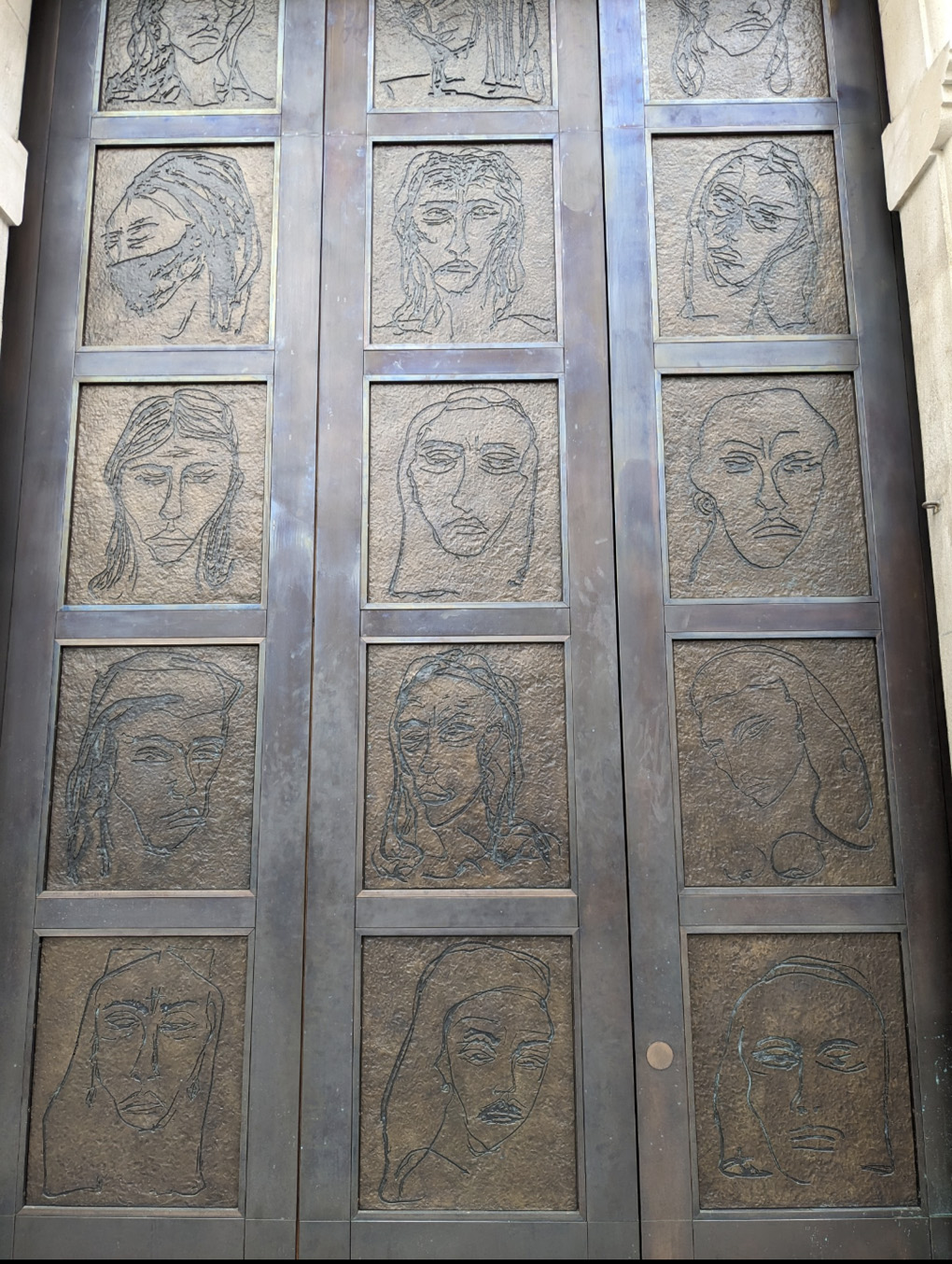Doors by Tracey Emin featuring many faces sketched into bronze