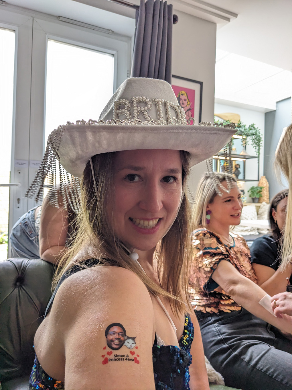 Bride cowboy hat, sparkles and a transfer tattoo of husband and cat.