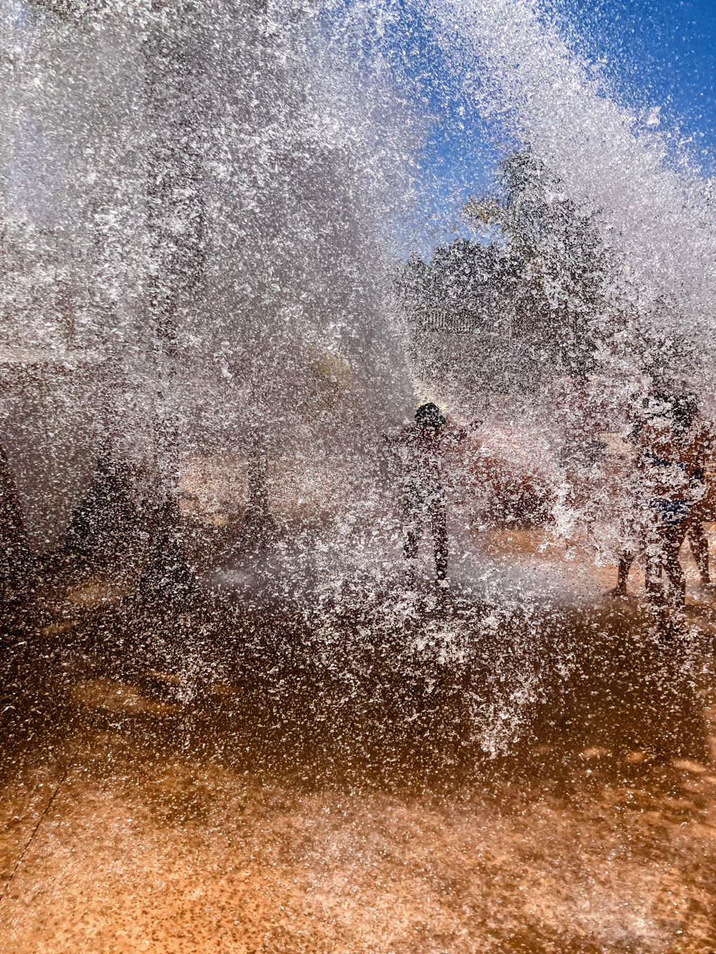 Image of water being dropped from a great height onto my 7-year-old son. There's so much water infact barely anything else can be seen in the photo, just a mass of water droplets!