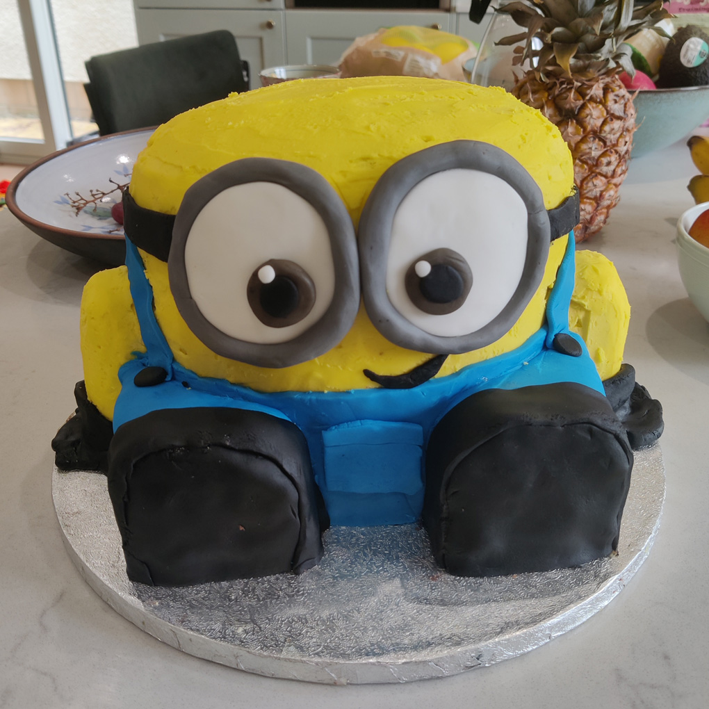 A large bright yellow Minion called dave in cake form sitting on our kitchen worktop