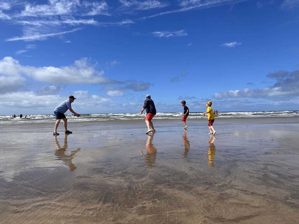 Family playing ball games on the beach