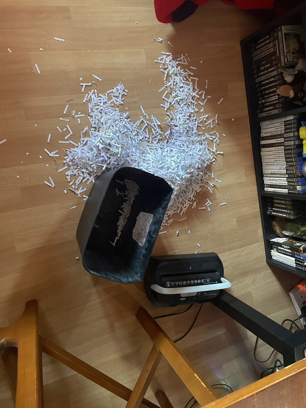 A shredder that has decided to leave a lot of its paper contents on the floor