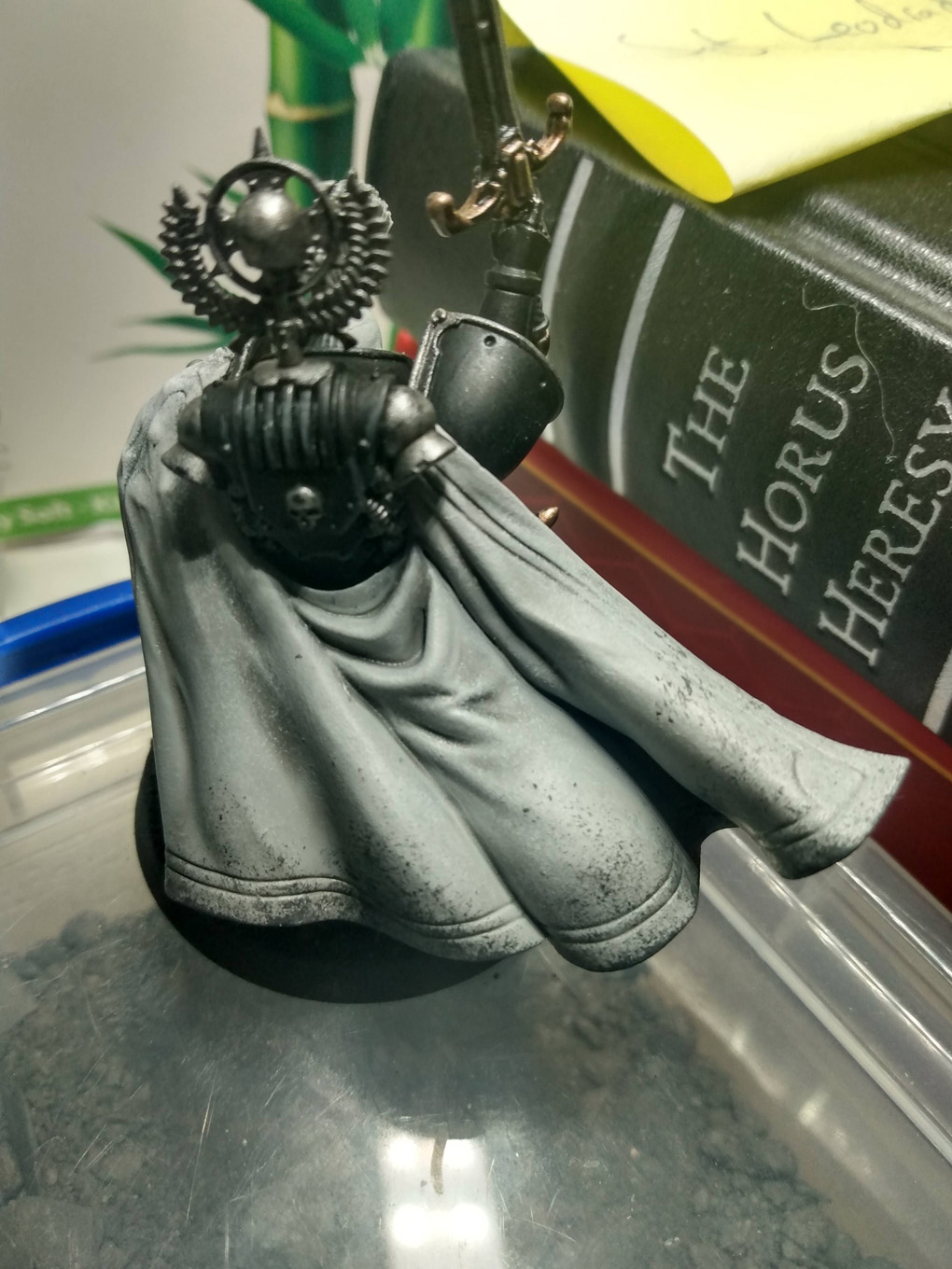 A plastic Warhammer model has a slightly dirty white cloak from a messy battlefield