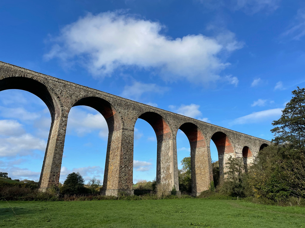 A huge old railway viaduct against a blue sky