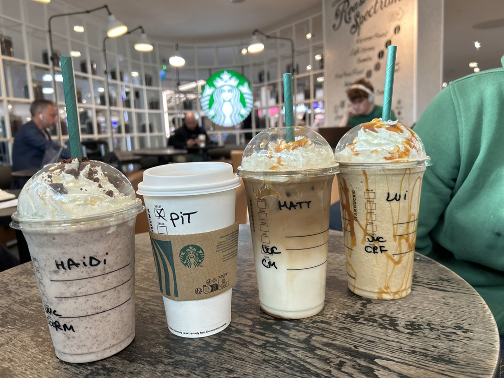 Four Starbucks coffee mugs with names Haidi, Pit, Matt and Lui written on them