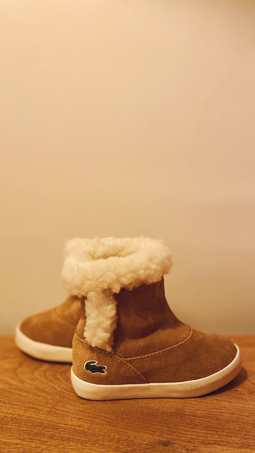 A pair of fur-lined, suede, light-brown baby boots.