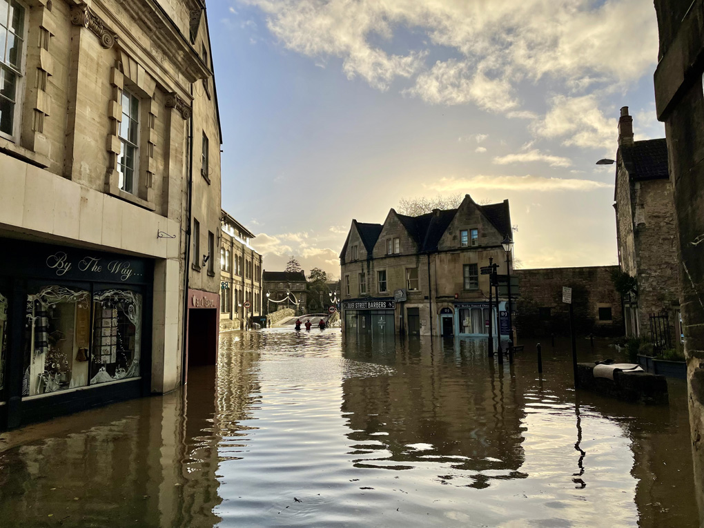 A flooded street with shop fronts under water