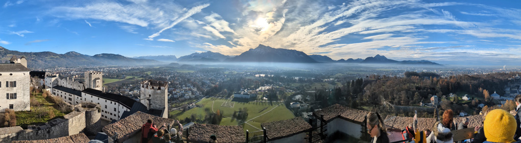 A panorama from the top of a castle looking towards a mountain on a sunny cold day