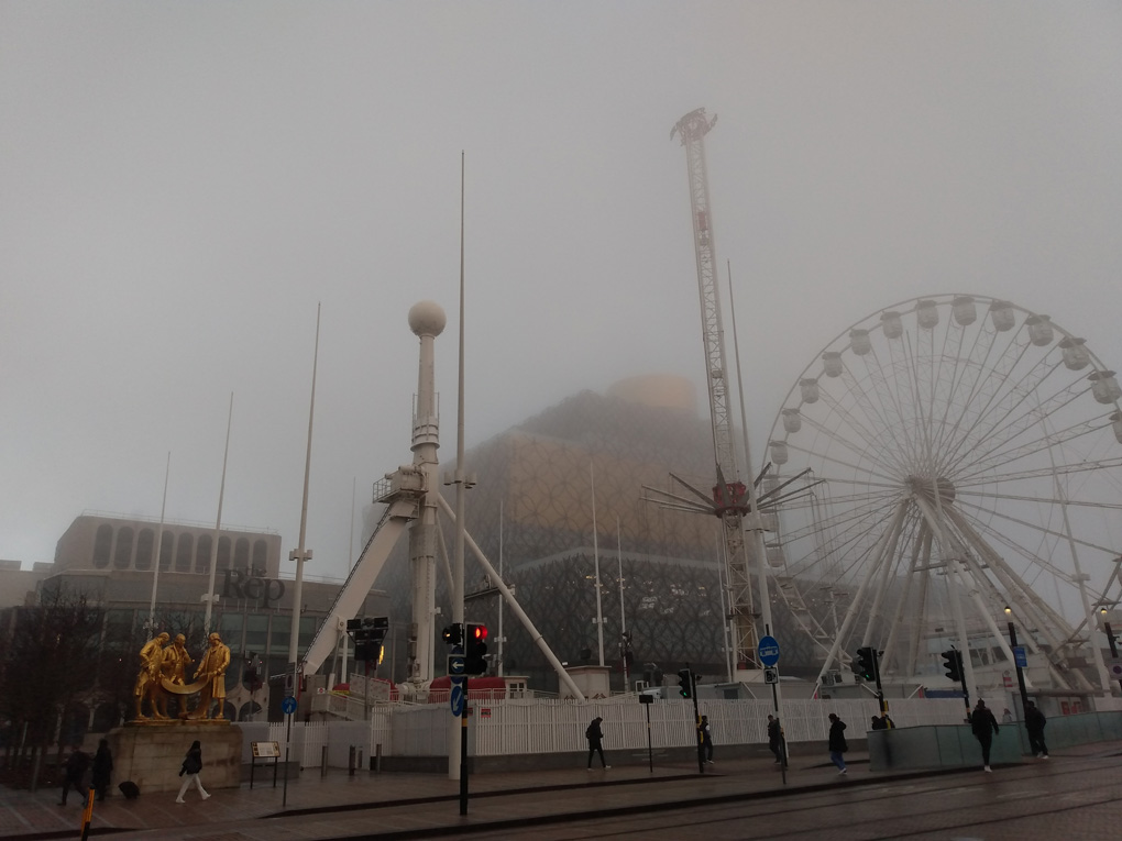 Buildings loom out of the fog