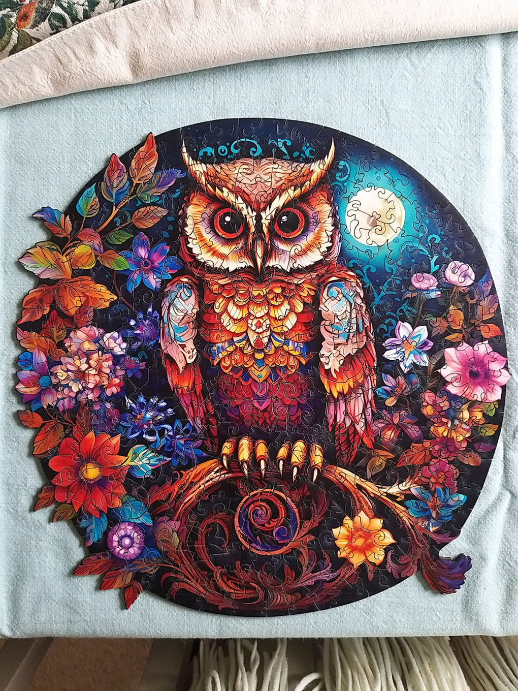 Jigsaw puzzle picture of an owl in a tree surrounded by flowers and a full moon