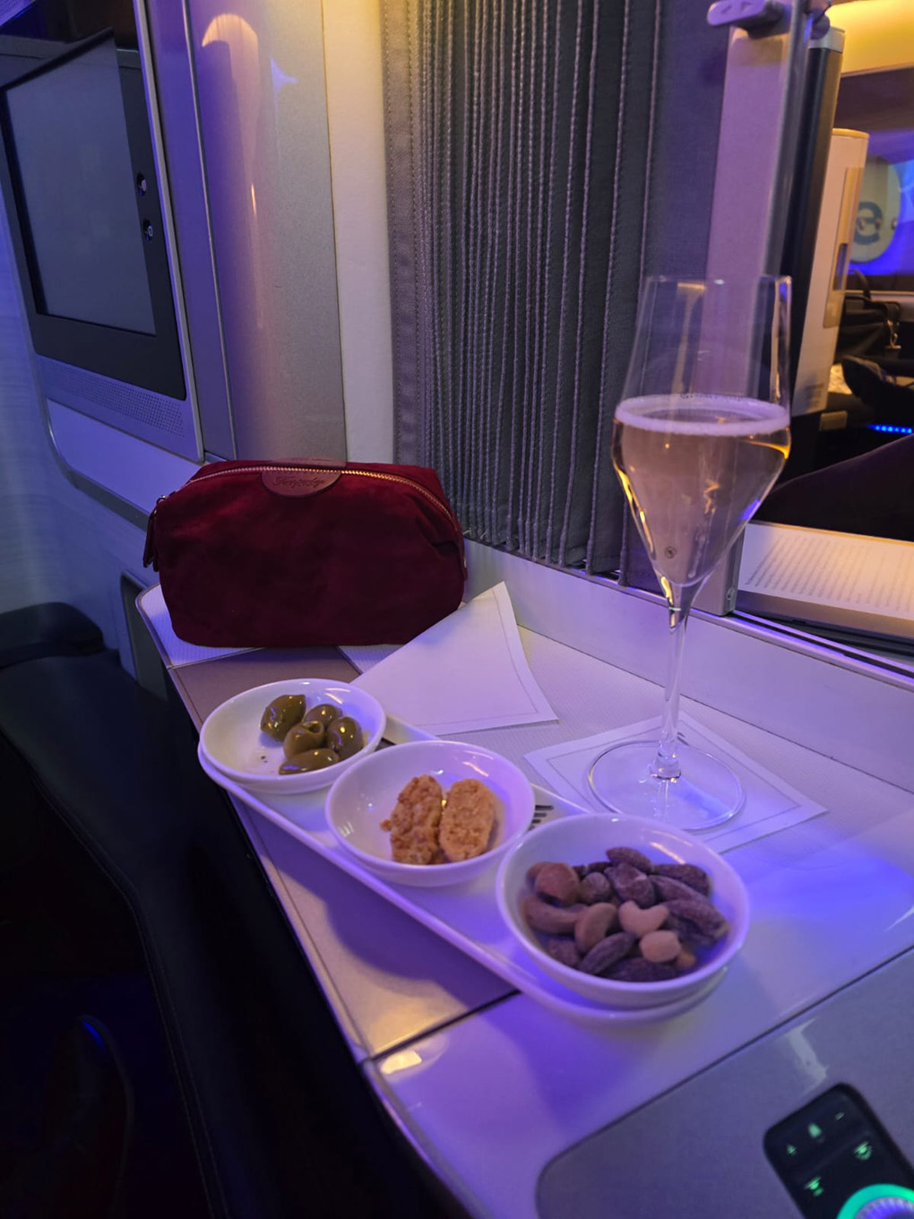 Nibbles and wine on a tray in first class on an aeroplane