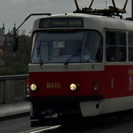 A Tatra T3 tram with Prague Castle in the background. Crossing over bridge with sun rays breaking out from behind clouds.
