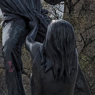 A statue of a person falling and another reaching to grab them