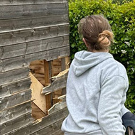 Lady with sledgehammer destroying a shed.