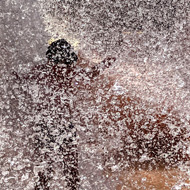 Image of water being dropped from a great height onto my 7-year-old son. There's so much water infact barely anything else can be seen in the photo, just a mass of water droplets!