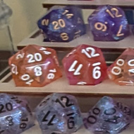 Sets of dice on display stands in a perspex case