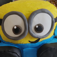 A large bright yellow Minion called dave in cake form sitting on our kitchen worktop