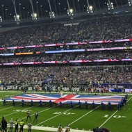 Flags out on an American Football field with fireworks before the game