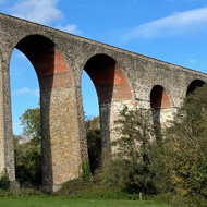 A huge old railway viaduct against a blue sky