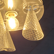 Glass waffle cone light fixtures hanging from a black ceiling