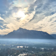 A panorama from the top of a castle looking towards a mountain on a sunny cold day