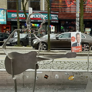 A plaza which faces a busy road and with a street of shops/bars in the background (featuring a Hooters. It's that kind of area). In the foreground are four human-size cookie-cutter-style statues of The Beatles holding guitars or, in the case of Pete Best/Ringo Star, sitting behind a drum kit.