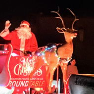 Santa on the back of a trailer with my boys excitedly watching on and waving.