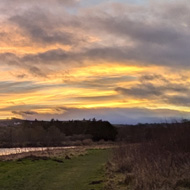 A colourful sunset over the Eildon hills with the river Tweed winding in the foreground