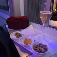 Nibbles and wine on a tray in first class on an aeroplane