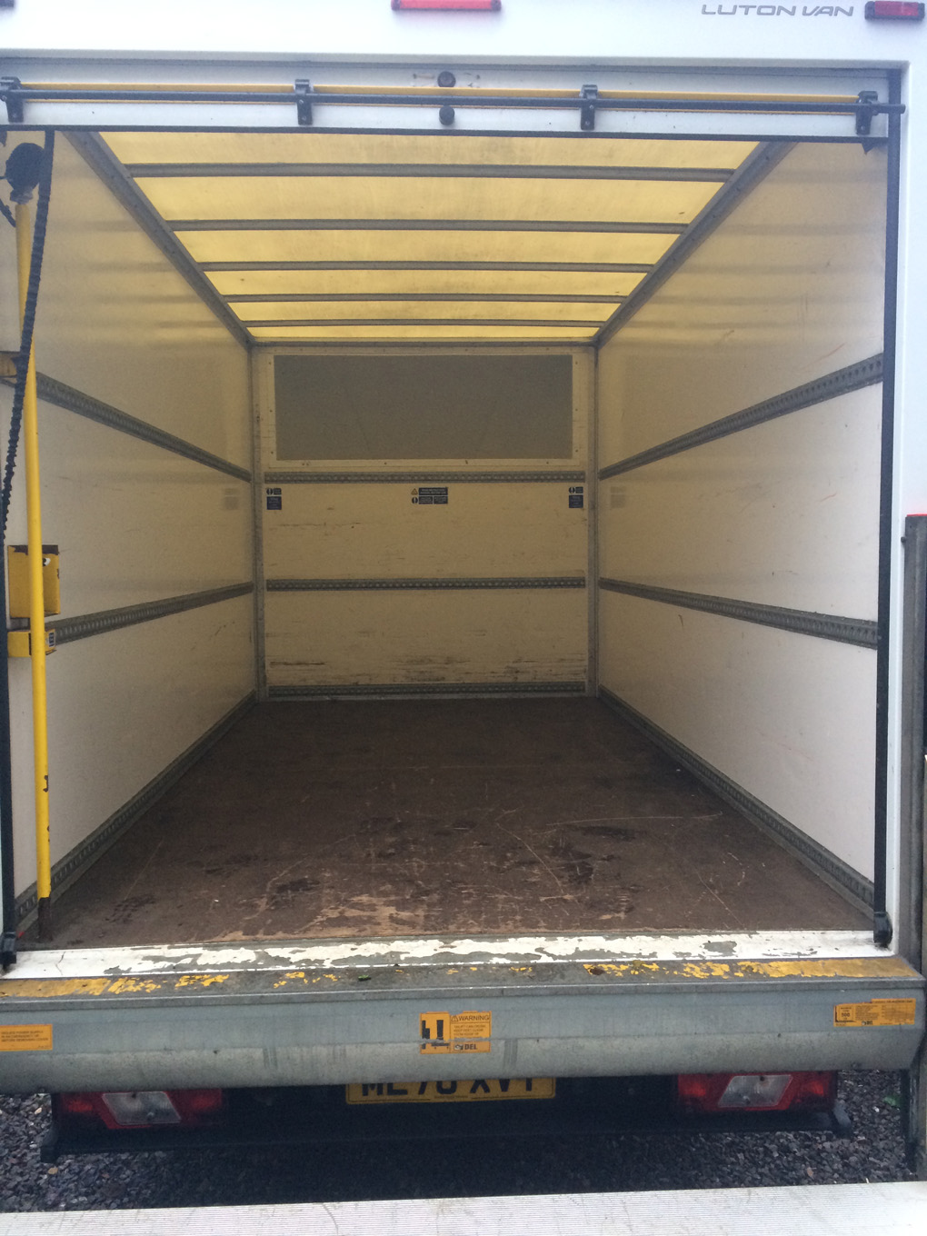 Looking inside the back door of an empty Luton van.