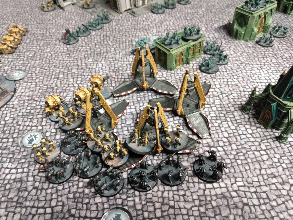 Small plastic miniatures close in to melee combat around their drop craft