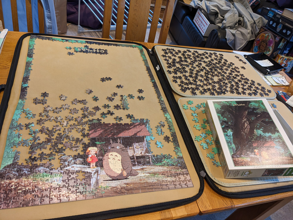 A jigsaw puzzle with the edges completed a small scene at the bottom and a big gap remaining to be filled with a giant tree