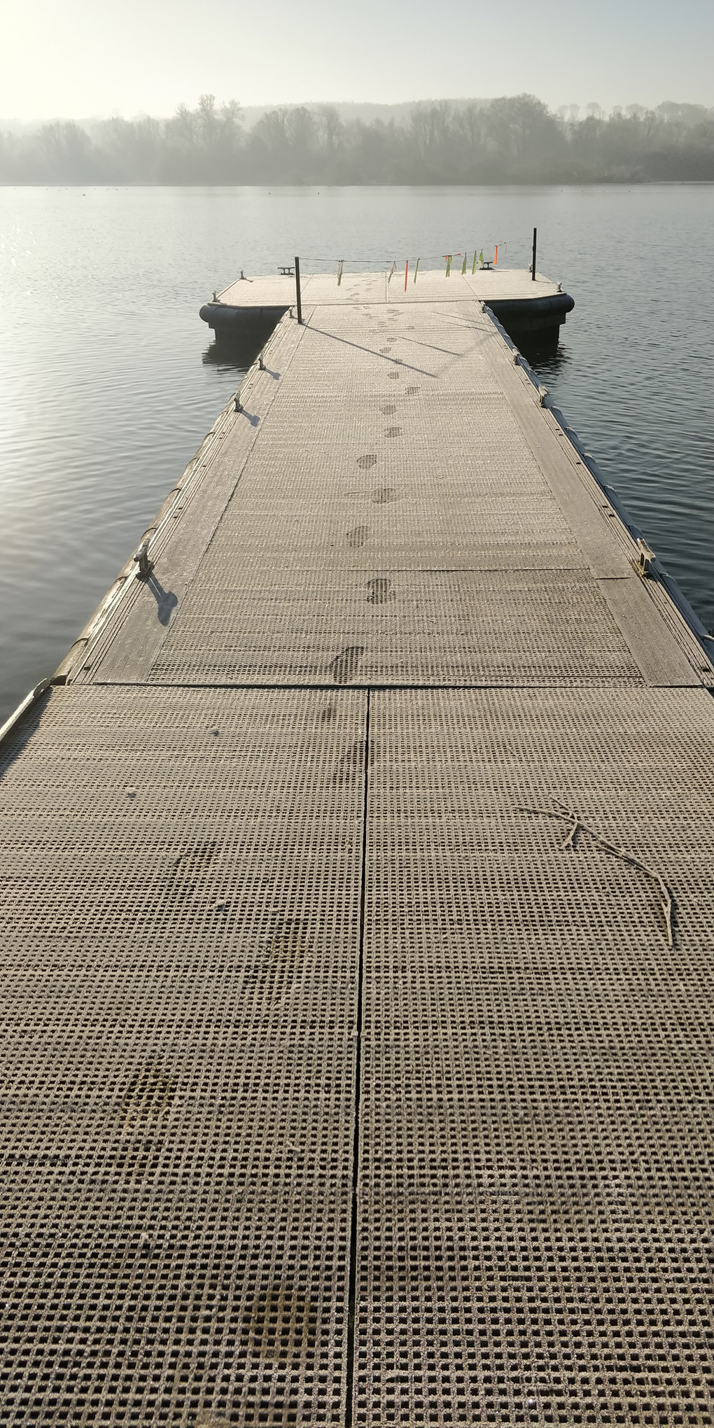 Sun rises over a frosty lake mooring pontoon