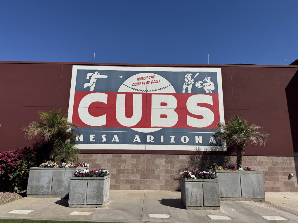 Sign for Cubs baseball with flower pots in front