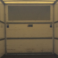 Looking inside the back door of an empty Luton van.