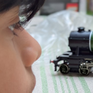 Picture if child looking at a Hornby Flying Scotsman model on a table